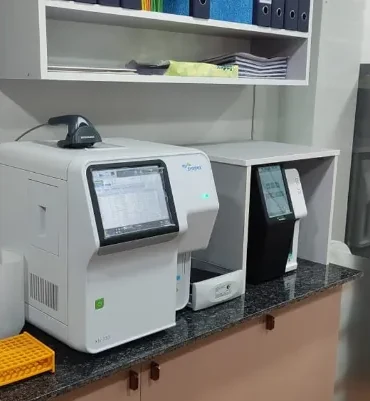 Haematology analyser with barcode scanner beside record storage shelving