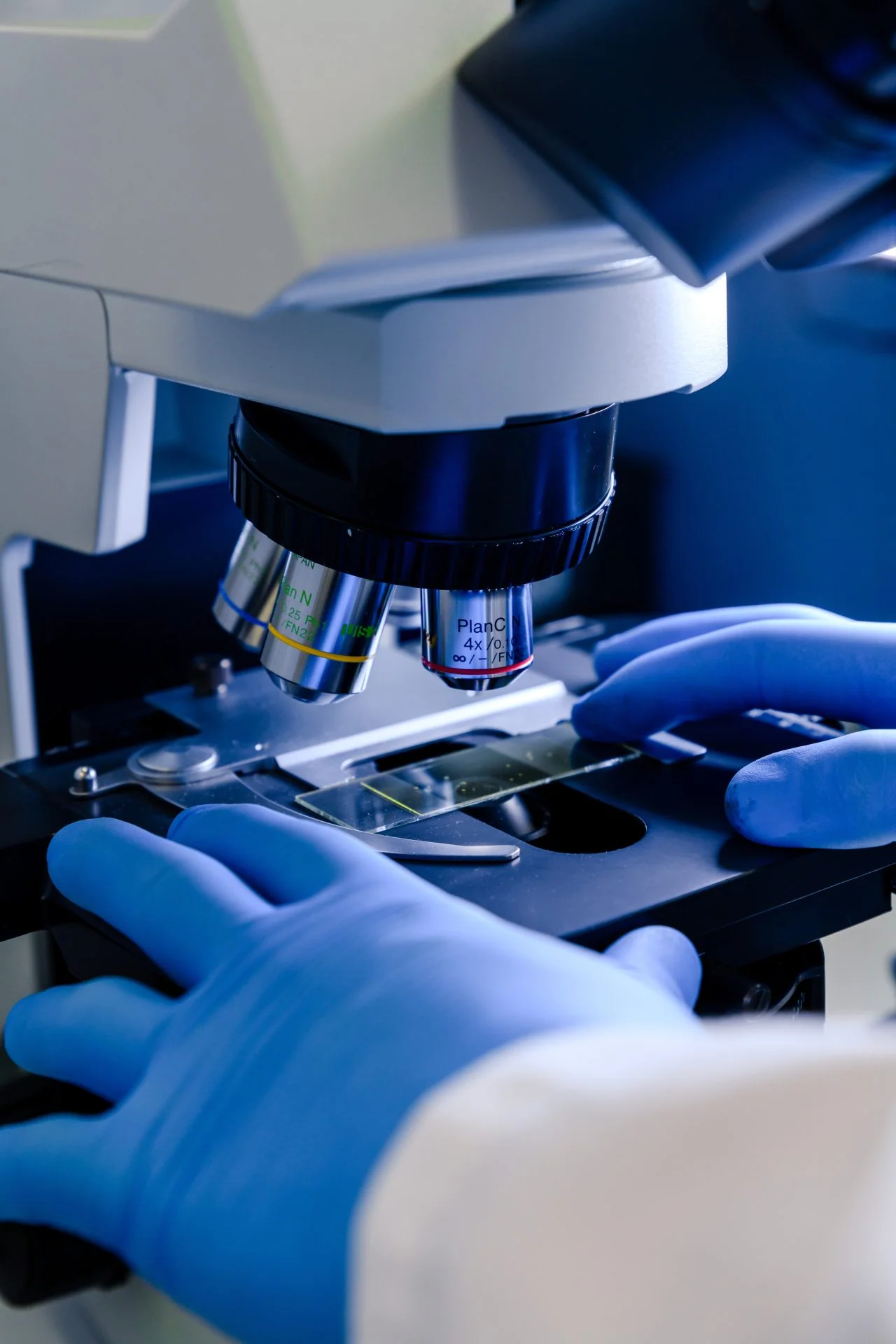 Laboratory scientist reviewing samples under a microscope